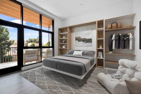 A bedroom with a large bed and a clothing rack.