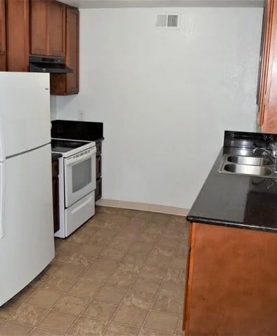 a kitchen with a refrigerator and a stove and a sink
