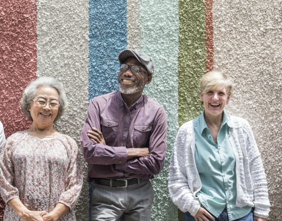 a group of people standing in front of a colorful wall