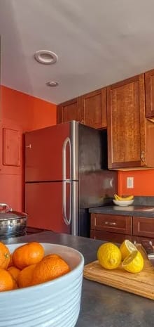 a kitchen with a bowl of oranges on the counter