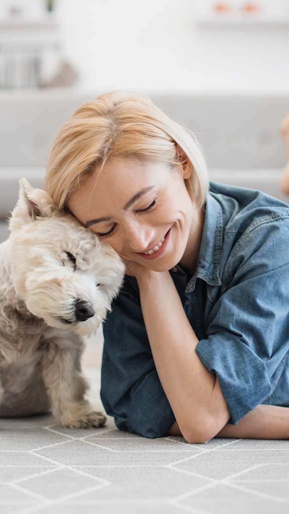 A person and her dog cuddling at PALMETTO RIDGE Apartments, TITUSVILLE, Florida