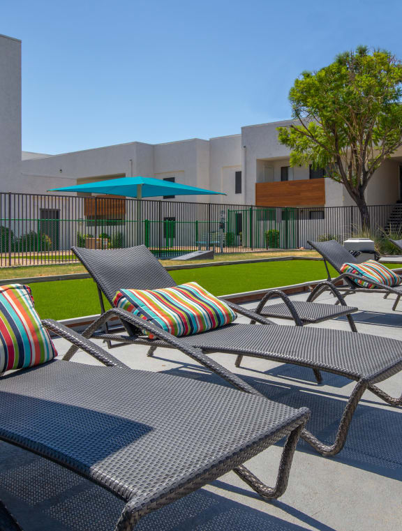a courtyard with a playground and yellow chairs in front of an apartment building