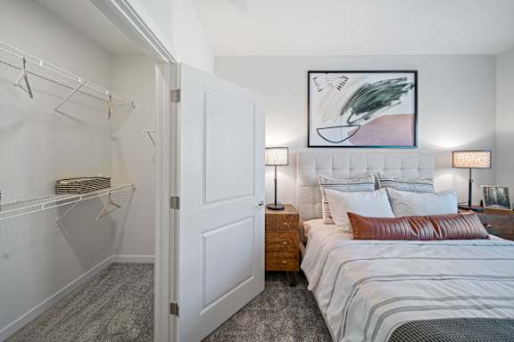 A bedroom with a large bed and a painting on the wall.