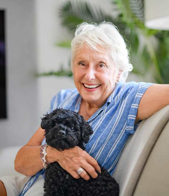 an older woman sitting on a couch smiling