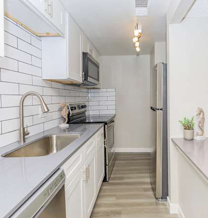 a kitchen with white cabinets and a sink and a refrigerator