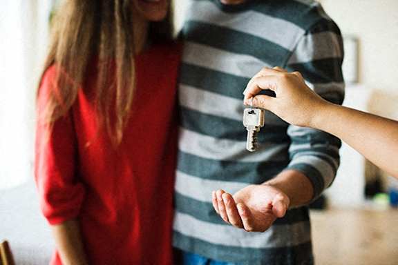 a person handing a key to a person holding their hand