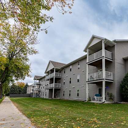 Grand Forks, ND Primrose Court Apartments. Exterior of a three level building with balconies and patios