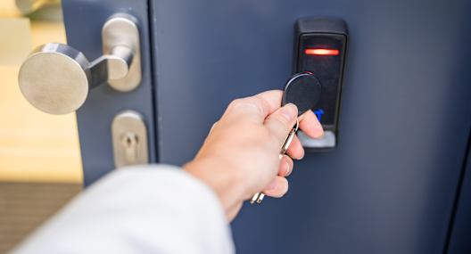 A person is opening a door with a keypad lock.