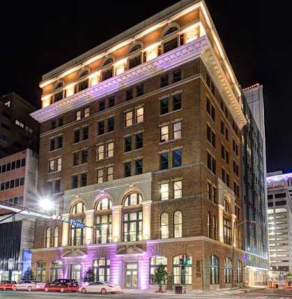 A large building with a lot of windows is lit up at night.