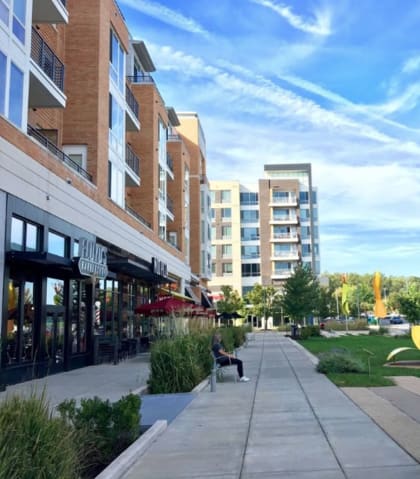 a view of a sidewalk with a park and buildings