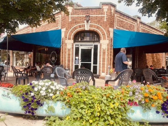 the front of a brick building with blue umbrellas