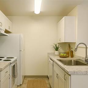 A kitchen with white appliances and cabinets.