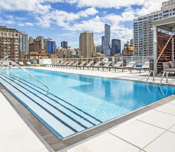 A swimming pool with a city skyline in the background.