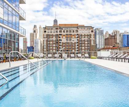 A large indoor swimming pool with a city skyline in the background.