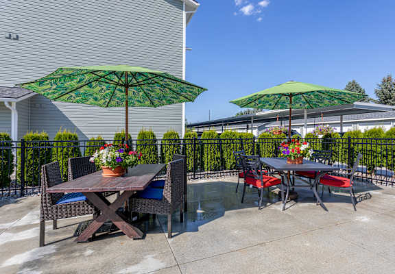 a patio with tables and chairs and umbrellas