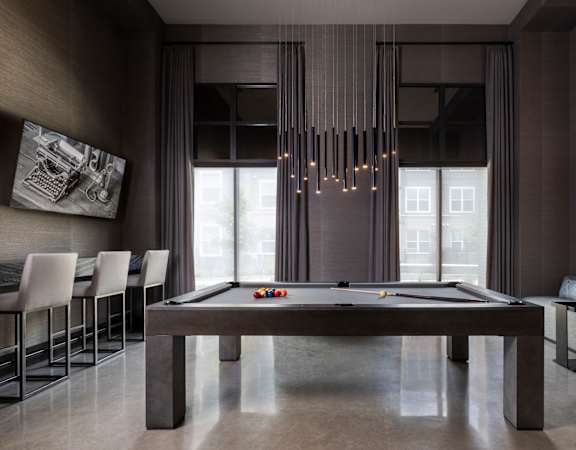 A pool table in a room with a light hanging from the ceiling.