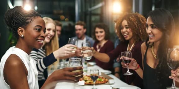 a group of people sitting around a table drinking wine