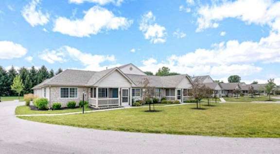 a house with a lawn and a road in front of it