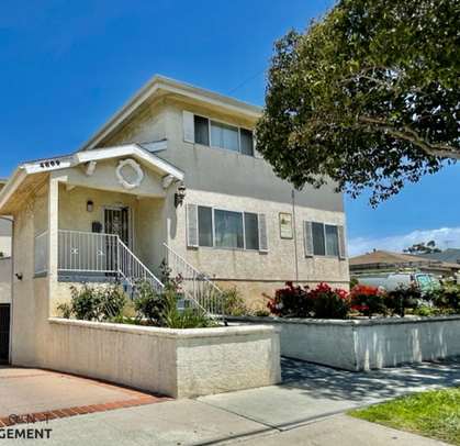 A two-story house with a balcony on the second floor is for sale.