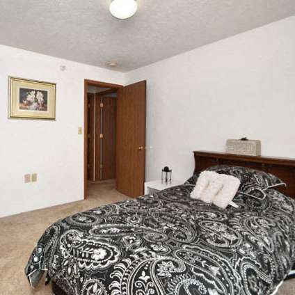 a white bedroom with a large bed and a window