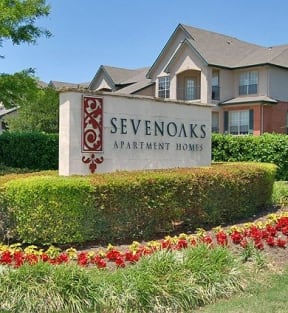 a sign in the grass in front of a house  at Seven Oaks Apts, Garland, TX