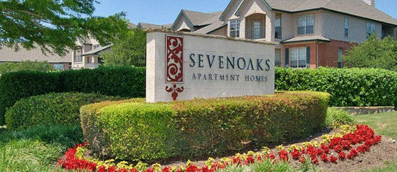a sign for sevenlinks apartments in front of a house