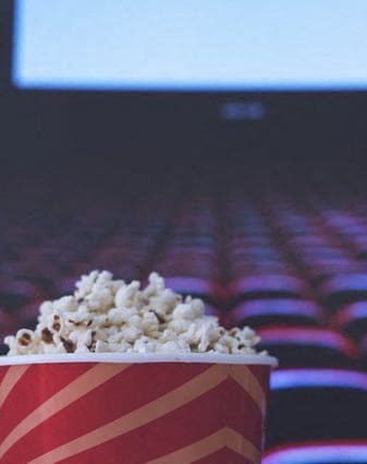 a cup of popcorn in front of an empty auditorium