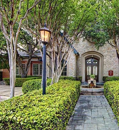 a house with a courtyard and trees in front of it