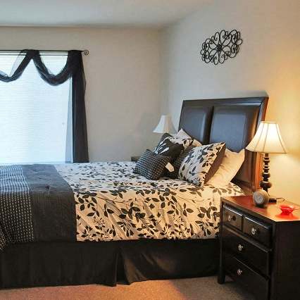a white bedroom with a large bed and a window