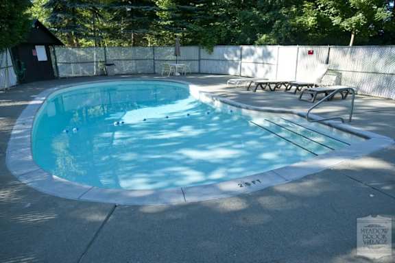 A small round pool with a white fence around it.