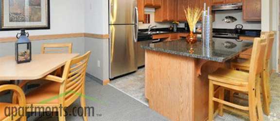 A kitchen with wooden cabinets and a granite countertop.