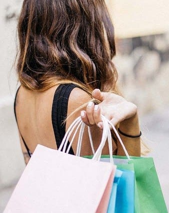 a woman carrying shopping bags and holding three shopping bags