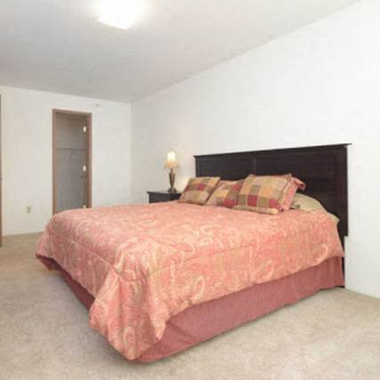 a white bedroom with a large bed and a window