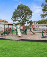 a playground in the middle of a grass field at Courthouse Green Apartments, Chesterfield