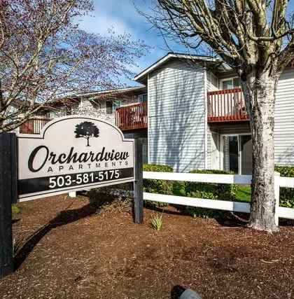 A sign for Orchardview Apartments stands in front of a building.