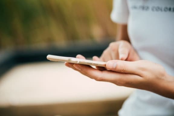 a person holding a cell phone in their hands at Providence at Old Meridian Apartments , Indiana
