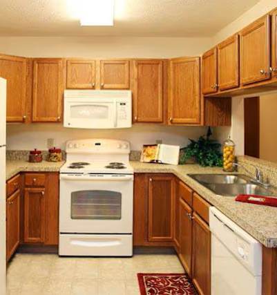 A kitchen with wooden cabinets and white appliances.