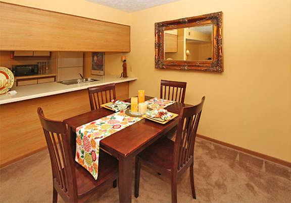 a dining room and kitchen with a table and chairs