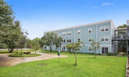 A large building with a green lawn in front.
