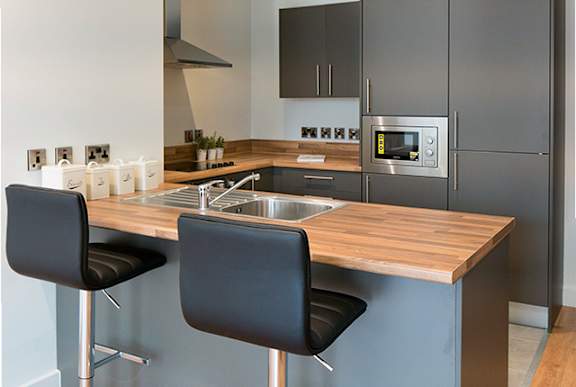 a kitchen with stainless steel appliances and a wooden counter top