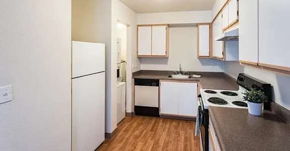 A kitchen with white cabinets and a black stove top.