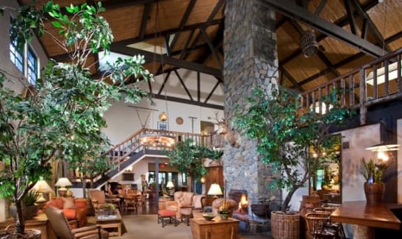 the lobby of a resort with a large living room and a staircase