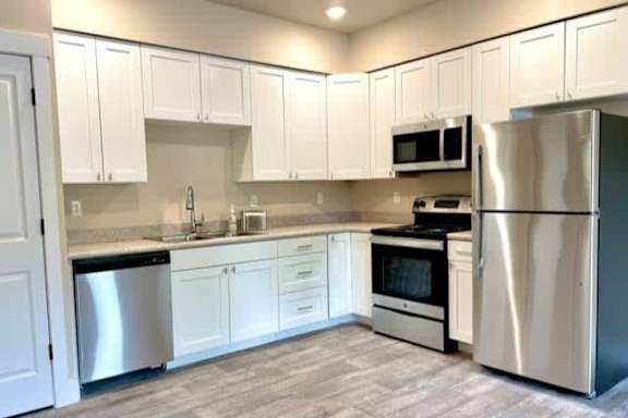 A kitchen with white cabinets and stainless steel appliances.