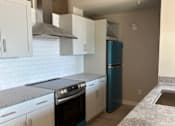 Thumbnail 5 of 18 - A kitchen with white cabinets and a black oven.