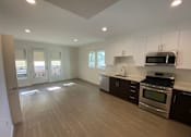 Thumbnail 22 of 41 - Living room and kitchen area with a sink, dishwasher, gas stove/oven, microwave and cabinets at unit 203, 739 South Ogden Drive.