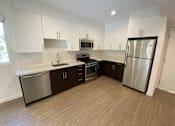 Thumbnail 21 of 41 - A kitchen with white cabinets, a refrigerator, gas stove, dishwasher and sink at unit 203, 739 South Ogden Drive.