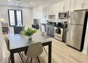 Thumbnail 1 of 13 - a kitchen with stainless steel appliances and a table with chairs