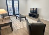 Thumbnail 9 of 13 - a living room with a couch a table and a television