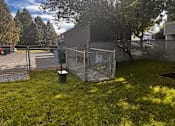 Thumbnail 5 of 8 - A fenced area with a trash can and a sign at Ironwood Apartments, Coeur d'Alene, Idaho