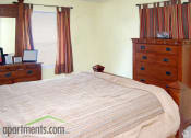 Thumbnail 17 of 36 - large carpeted bedroom with cedar dresser and windows with drapes